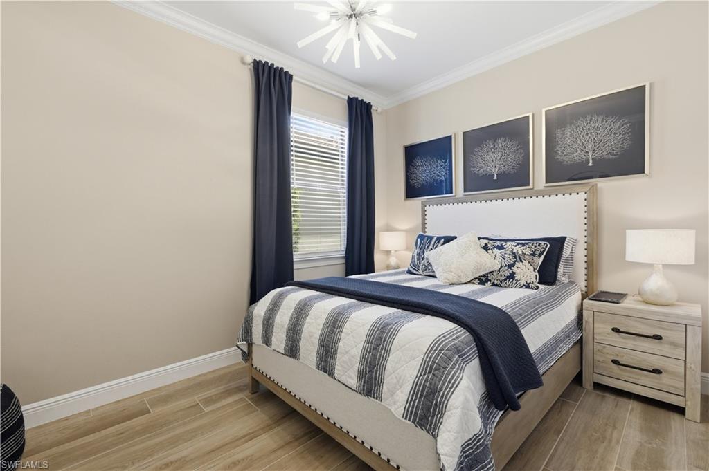 9761 Willet Court Naples, FL 34120 - Photo 9 of 44 a bedroom with a large bed and a chandelier