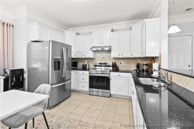 a kitchen with granite countertop a refrigerator stove and sink