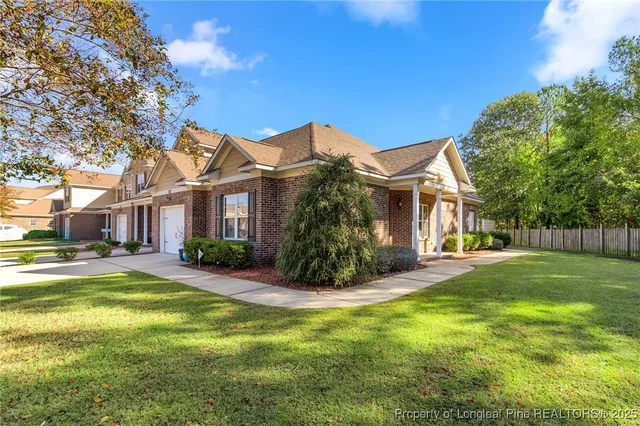a view of a house with a big yard and large trees