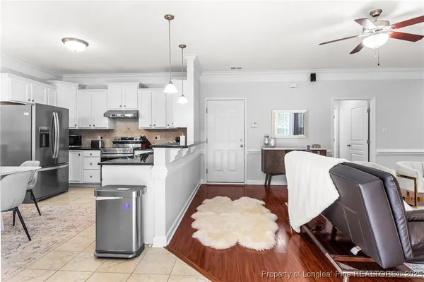 a kitchen with a dining table chairs stainless steel appliances and cabinets