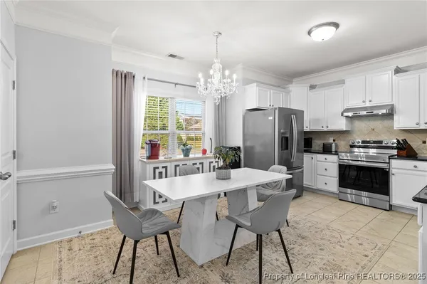 a view of a dining room with furniture a chandelier and wooden floor