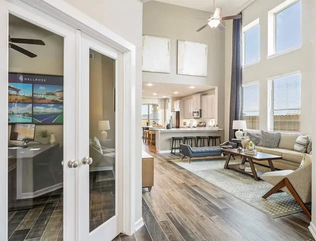 a living room with furniture a large window and wooden floor
