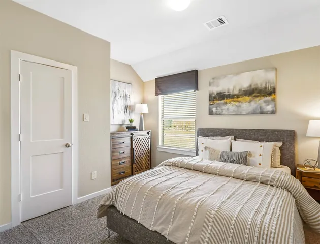 a bedroom with a bed and a painting on the wall