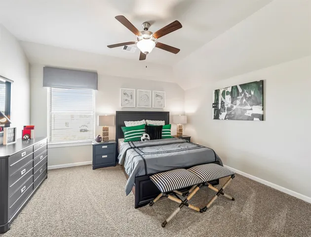 a bedroom with a bed dresser and furniture
