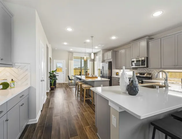 a kitchen with lots of counter space a sink appliances and cabinets