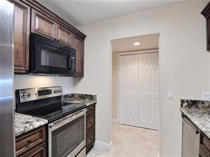 a kitchen with stainless steel appliances granite countertop white cabinets and stove top oven