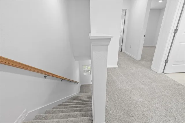 a view of staircase with white walls and a window