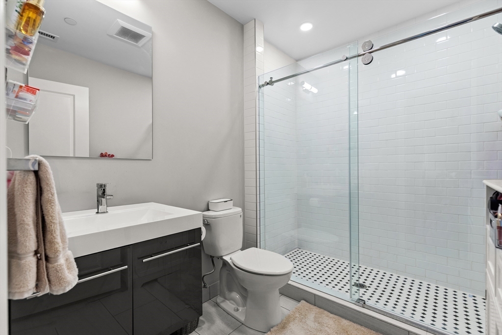 10 Taber Street, Unit 508 Boston, MA 02119 - Photo 10 of 11 a bathroom with a sink a toilet a shower and a mirror