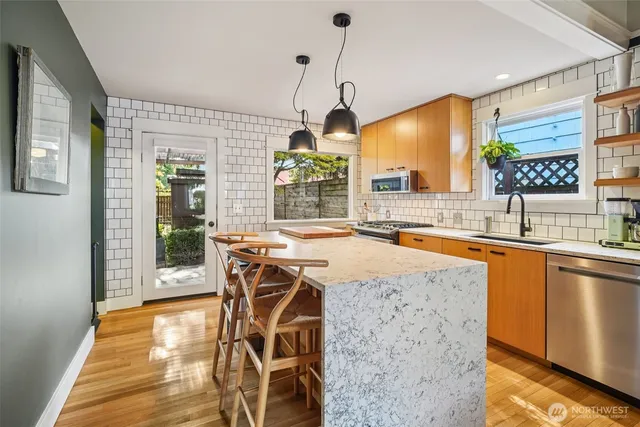 a kitchen with a table chairs sink and wooden floor