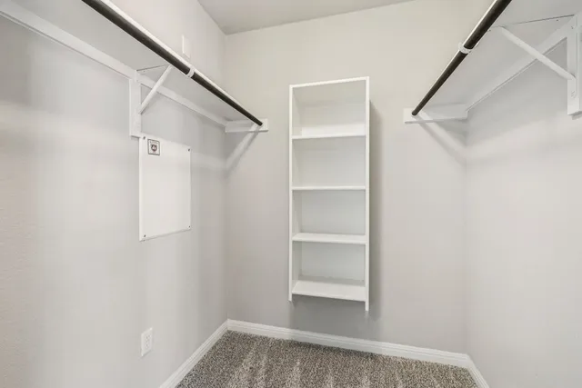 a view of walk in closet with empty racks