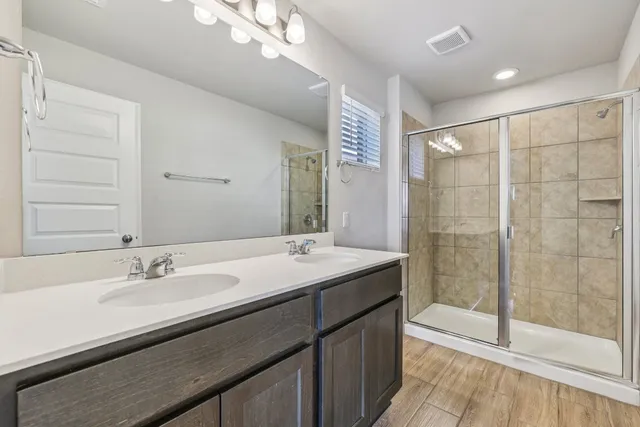 a bathroom with a sink double vanity and a shower