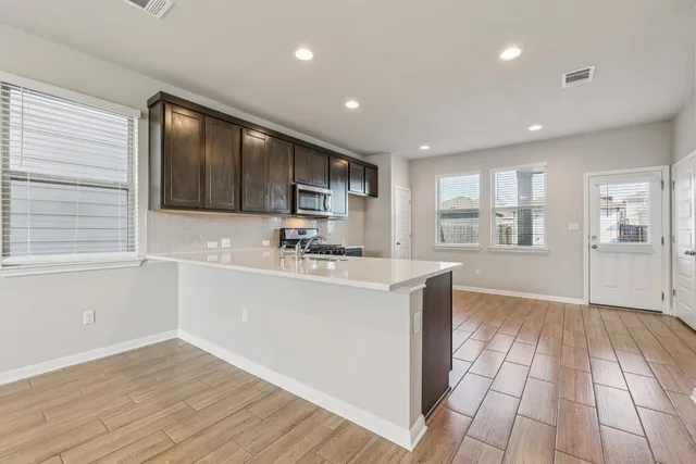 a view of kitchen with wooden floor and electronic appliances
