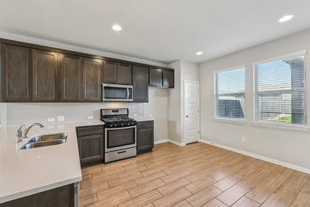a kitchen with granite countertop wooden cabinets and a stove top oven
