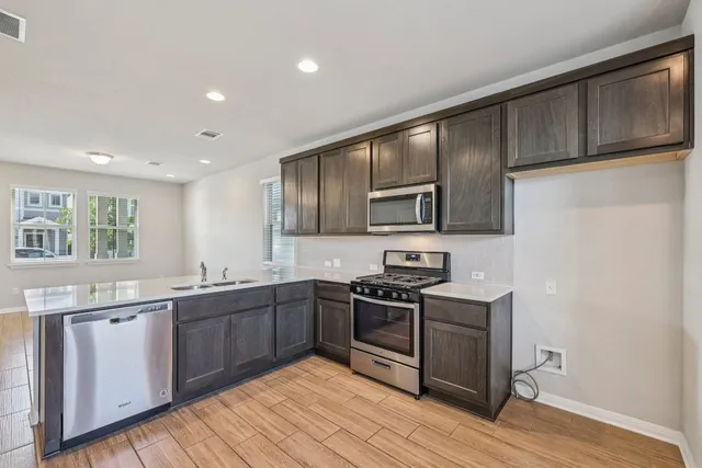a kitchen with stainless steel appliances granite countertop wooden cabinets stove top oven and sink