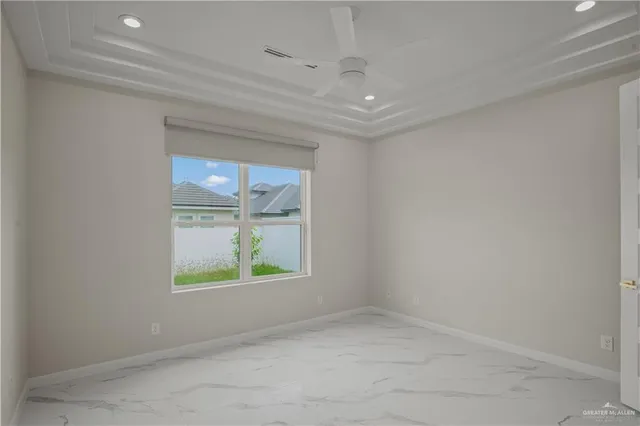 an empty room with a ceiling fan and window