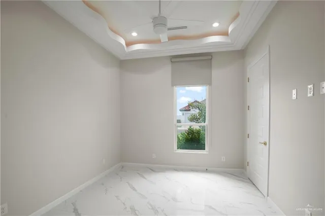 an empty room with windows and ceiling fan