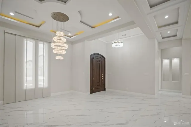 a view of a livingroom with a chandelier fan and windows