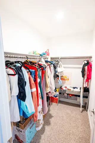 a view of walk in closet with clothes and shoes