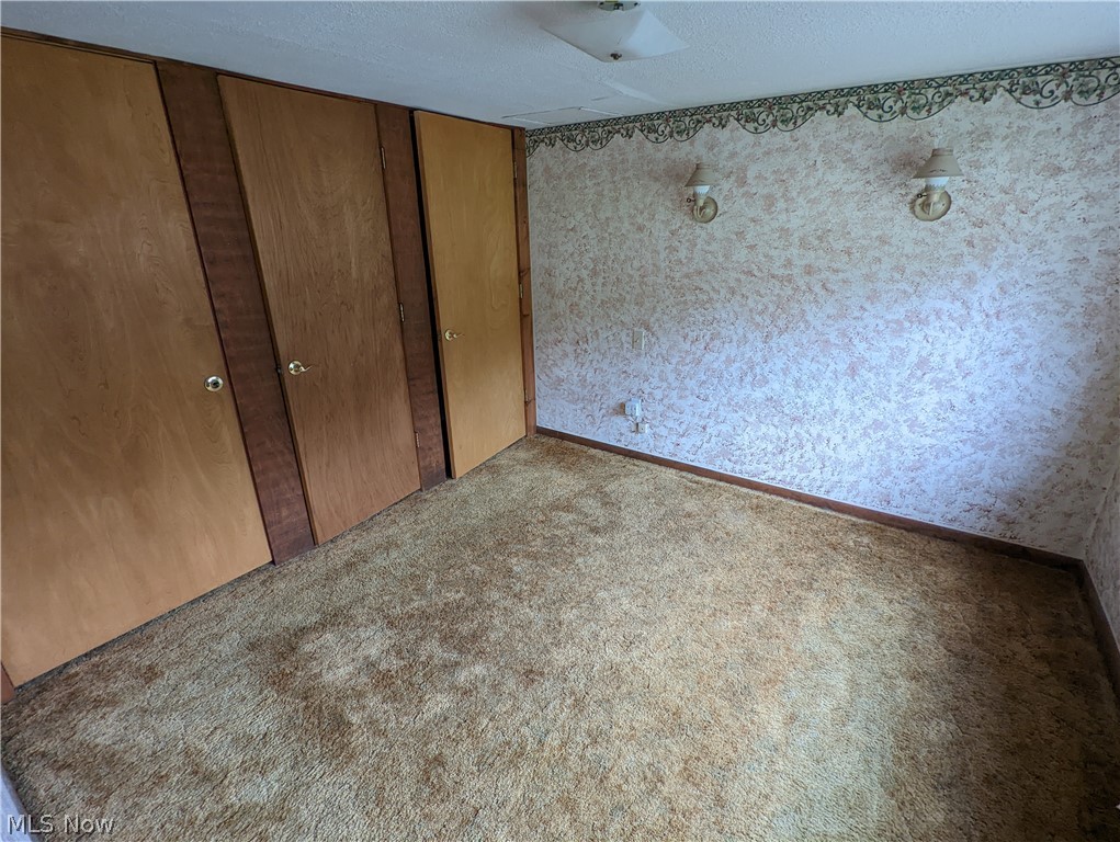 308 Thomas Road Lisbon, OH 44432 - Photo 4 of 13 Unfurnished bedroom with a closet, carpet floors, and a textured ceiling