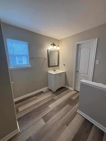 a bathroom with a granite countertop sink toilet mirror and bathtub