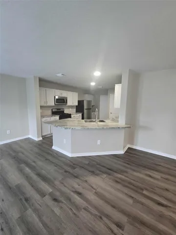 a large kitchen with stainless steel appliances kitchen island a large counter top and a stove top oven