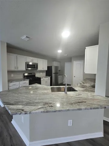 a view of kitchen with stainless steel appliances granite countertop refrigerator sink and stove