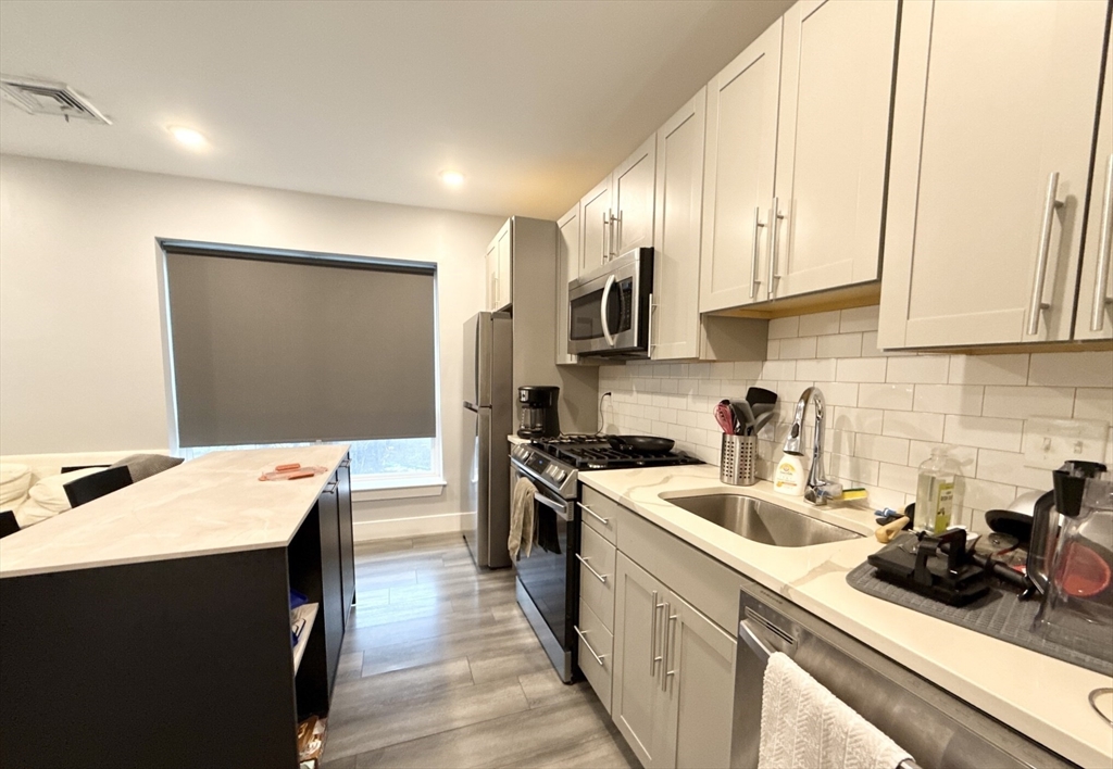 55 West Fifth Street, Unit 301 Boston, MA 02127 - Photo 11 of 11 a kitchen with a sink stove and cabinets