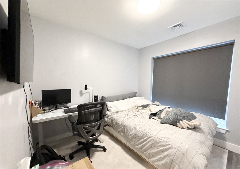 55 West Fifth Street, Unit 301 Boston, MA 02127 - Photo 7 of 11 a bedroom with a bed and a computer on a table