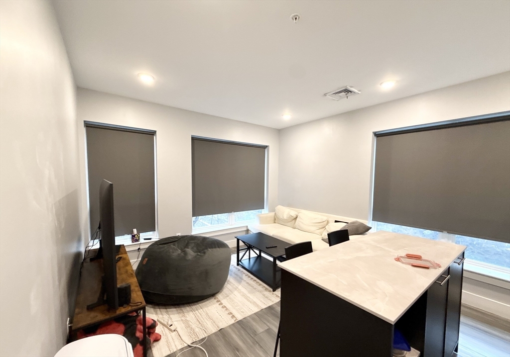 55 West Fifth Street, Unit 301 Boston, MA 02127 - Photo 9 of 11 a room with a table chairs and a wooden floor