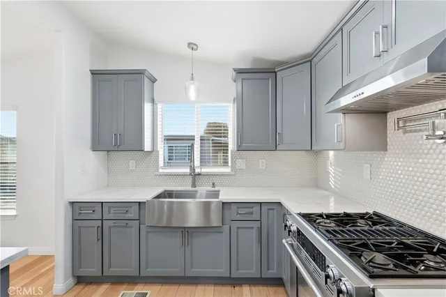 a kitchen with stainless steel appliances granite countertop a sink stove and cabinets