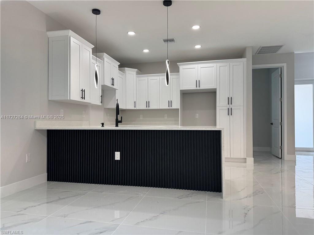 2902 49th Street Southwest Lehigh Acres, FL 33976 - Photo 11 of 26 a kitchen with kitchen island cabinets and refrigerator