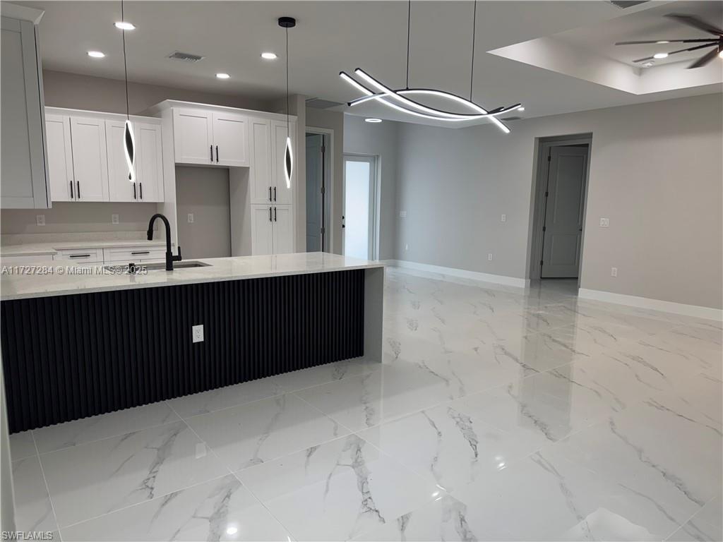 2902 49th Street Southwest Lehigh Acres, FL 33976 - Photo 12 of 26 a kitchen with a sink a refrigerator and cabinets