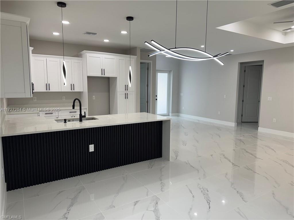 2902 49th Street Southwest Lehigh Acres, FL 33976 - Photo 13 of 26 a kitchen with a sink and cabinets