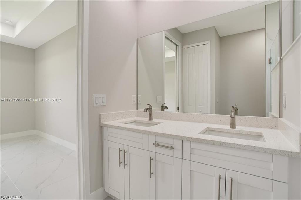 2902 49th Street Southwest Lehigh Acres, FL 33976 - Photo 17 of 26 a bathroom with a sink and a mirror