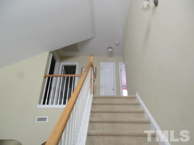 8504 Pillar Gate Lane Raleigh, NC 27613 - Photo 14 of 25 a view of staircase with lots of frames and white walls