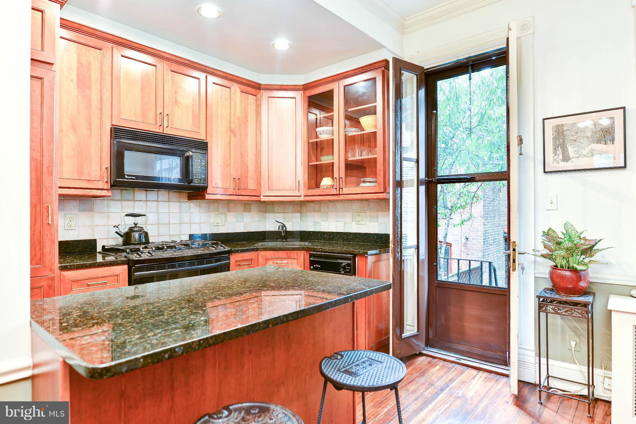 814 E Street Southeast Washington, DC 20003 - Photo 7 of 30 a kitchen with stainless steel appliances granite countertop a stove a sink and a microwave