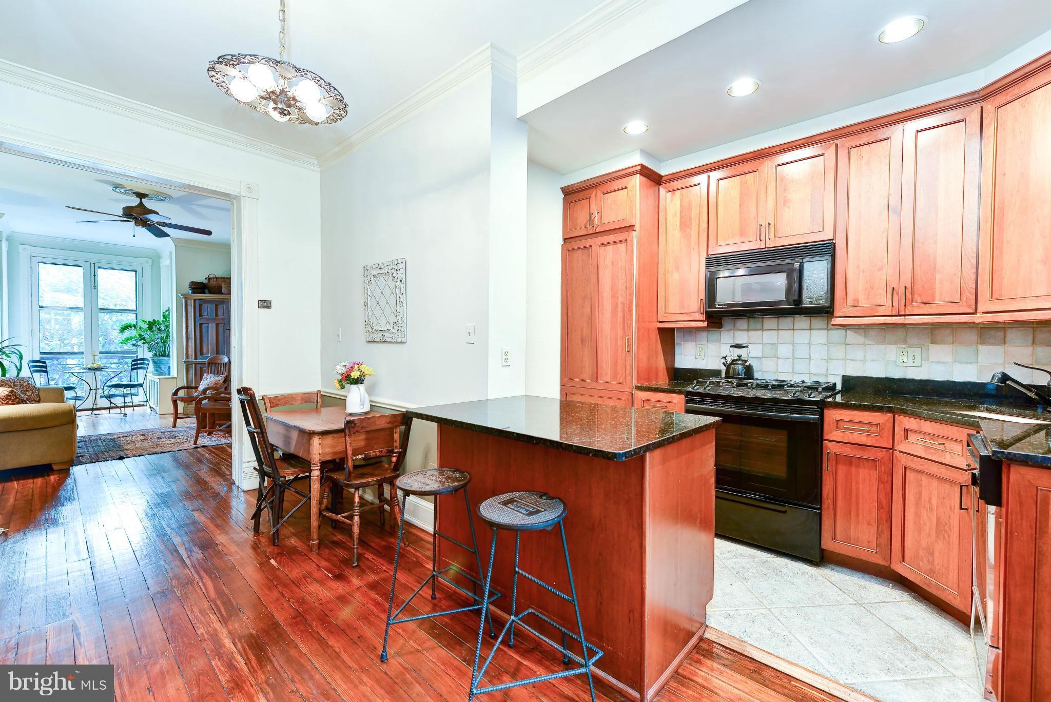 814 E Street Southeast Washington, DC 20003 - Photo 9 of 30 a kitchen with stainless steel appliances granite countertop wooden cabinets a dining table and chairs