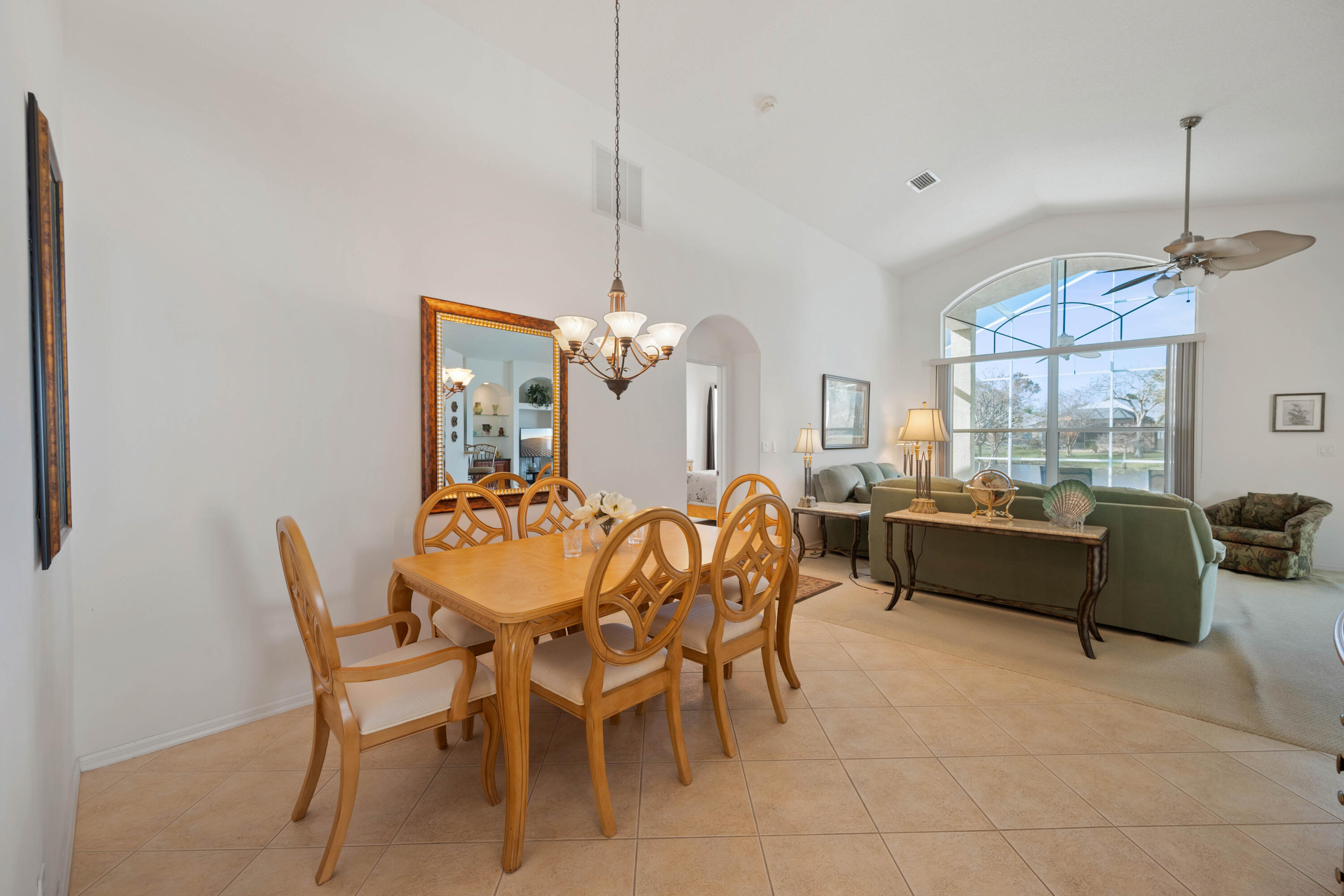 2096 Northwest Marsh Rabbit Lane Jensen Beach, FL 34957 - Photo 20 of 38 a dining room with furniture a chandelier and window