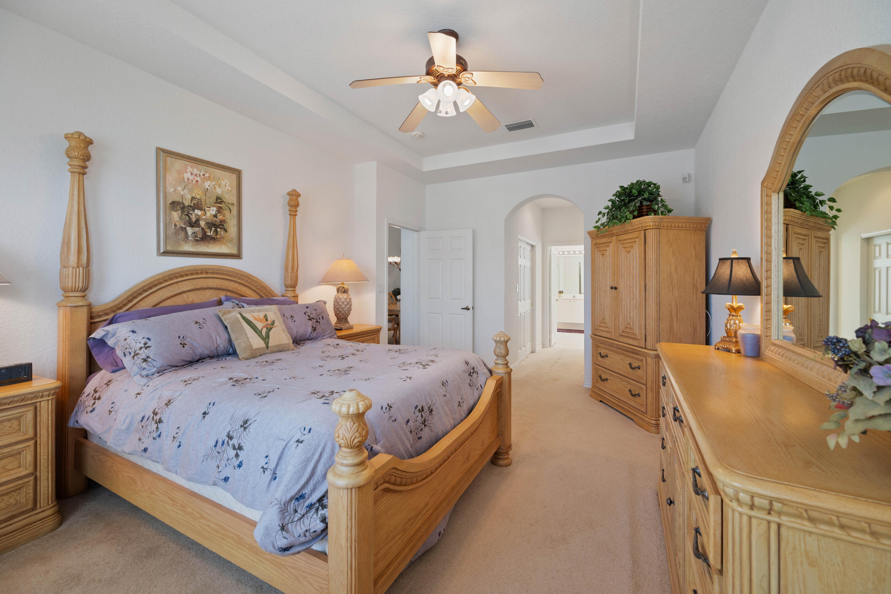 2096 Northwest Marsh Rabbit Lane Jensen Beach, FL 34957 - Photo 28 of 38 a bedroom with a bed and a chandelier