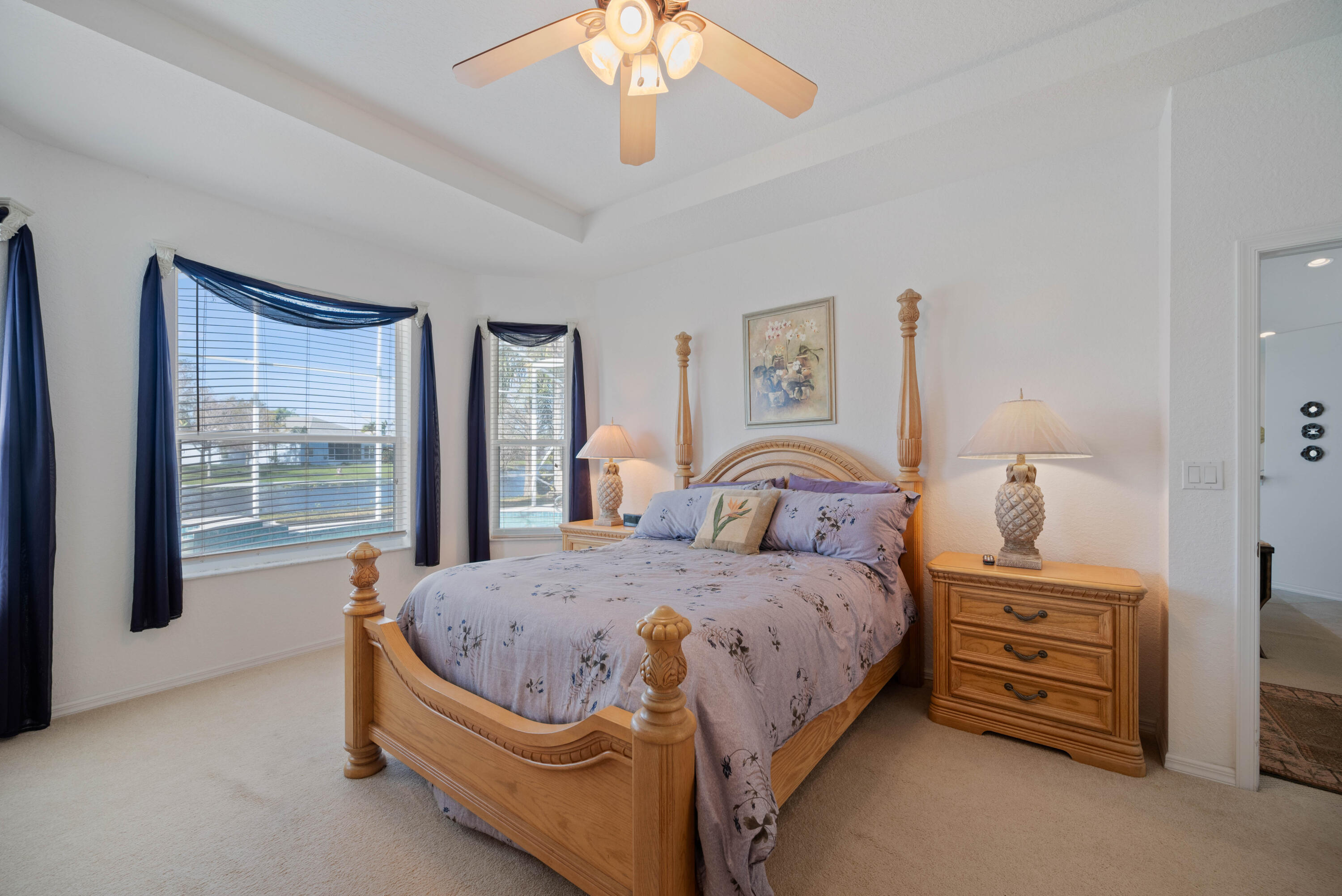 2096 Northwest Marsh Rabbit Lane Jensen Beach, FL 34957 - Photo 29 of 38 a bedroom with a bed and a chandelier