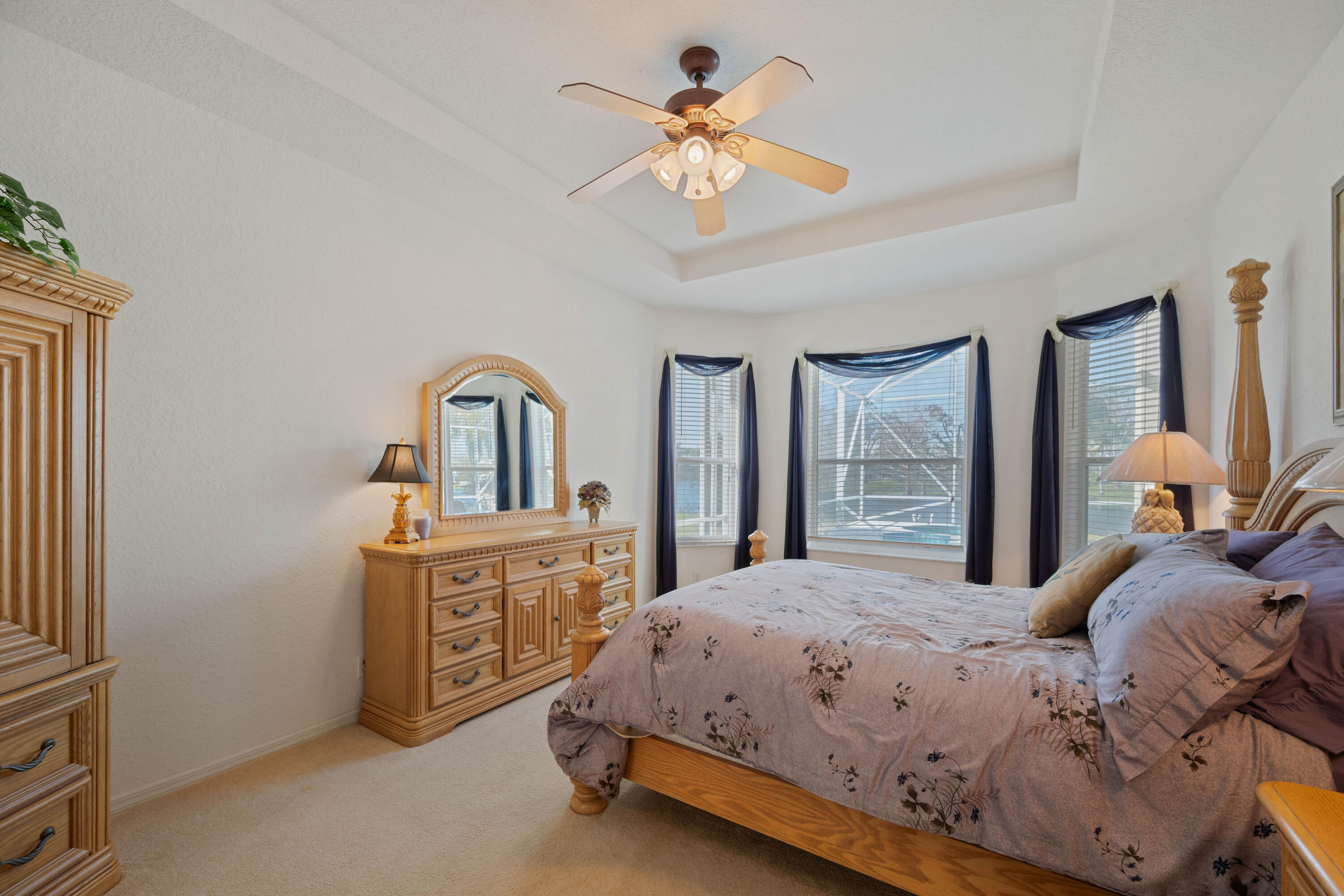 2096 Northwest Marsh Rabbit Lane Jensen Beach, FL 34957 - Photo 6 of 38 a bedroom with a bed and a chandelier