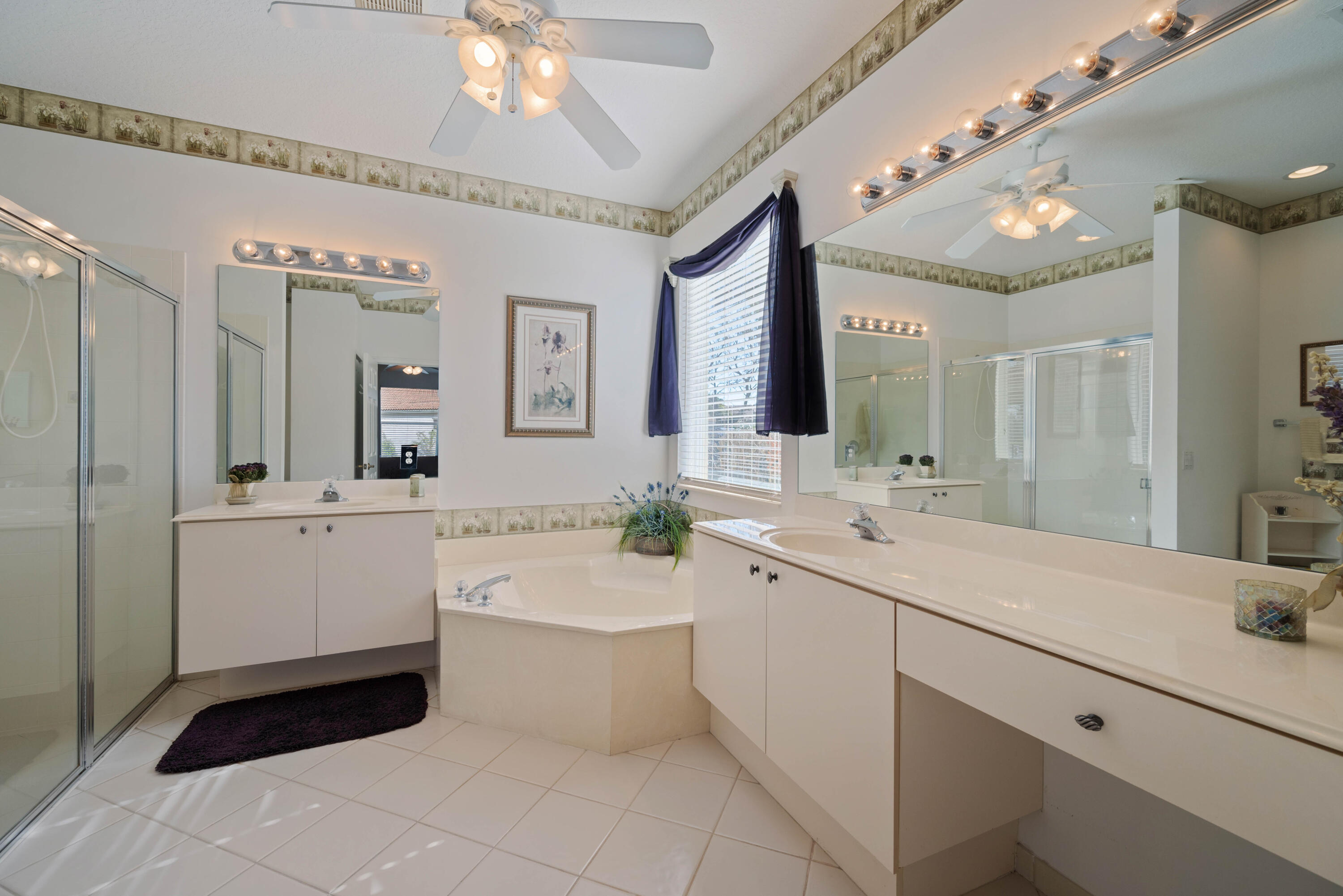 2096 Northwest Marsh Rabbit Lane Jensen Beach, FL 34957 - Photo 7 of 38 a bathroom with a sink a large mirror and a bathtub