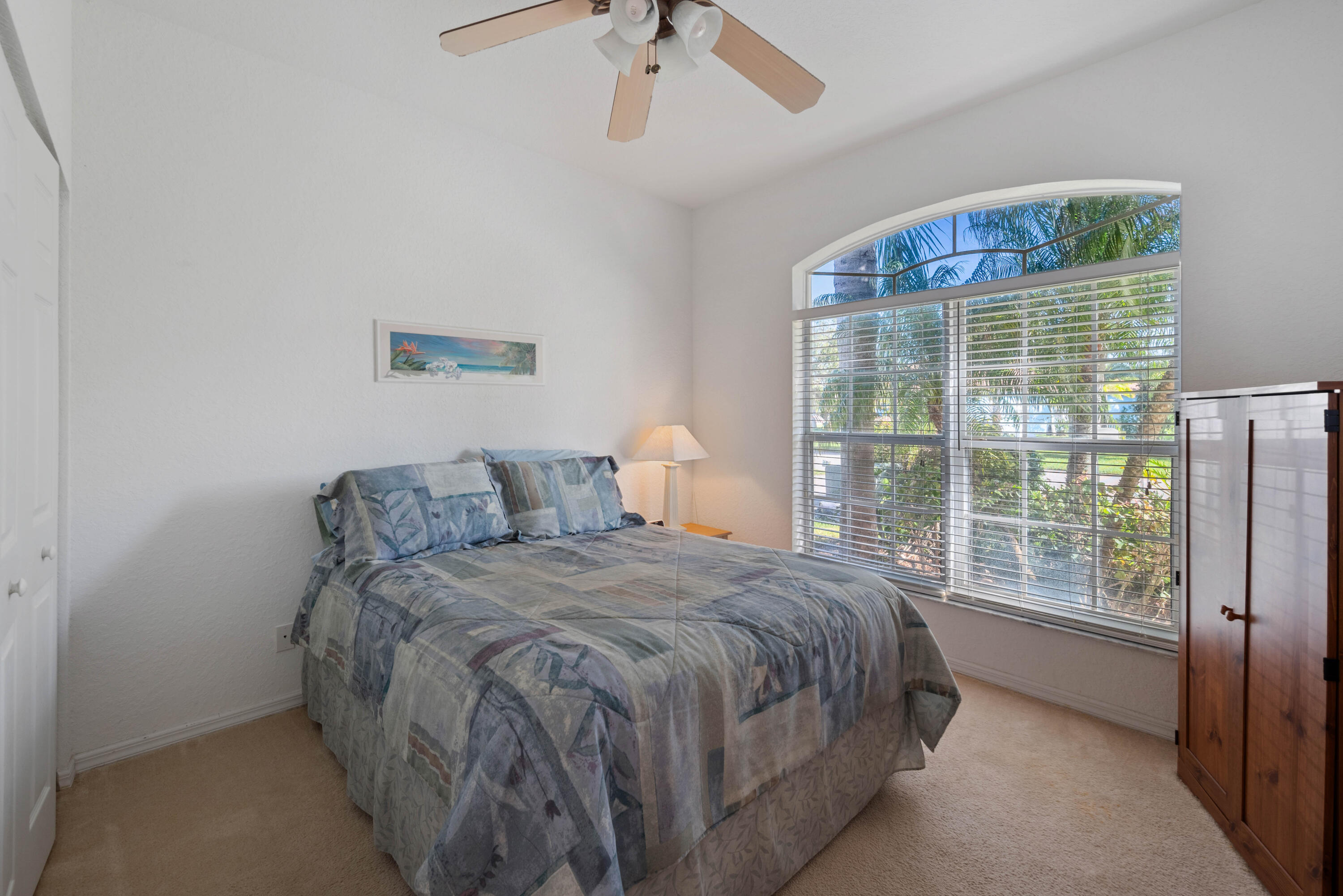 2096 Northwest Marsh Rabbit Lane Jensen Beach, FL 34957 - Photo 10 of 38 a bedroom with a bed and a large window