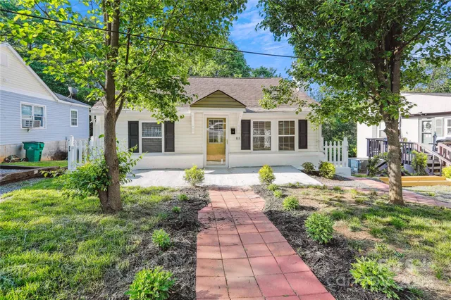 a front view of a house with a yard and potted plants