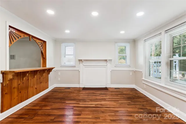 a view of a kitchen with wooden floor and a window