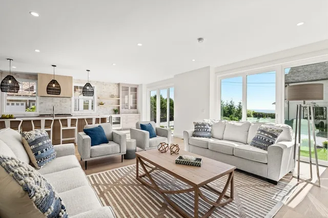 a living room with furniture and view of kitchen