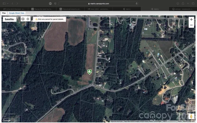 a view of a big house with a big yard and large trees