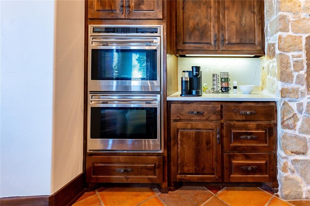 1180 McReynolds Road Sanger, TX 76266 - Photo 17 of 36 a kitchen with granite countertop a oven and cabinets