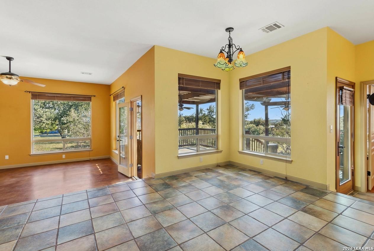9623 Requa Road Helotes, TX 78023 - Photo 13 of 49 a view of an empty room with window and chandelier fan