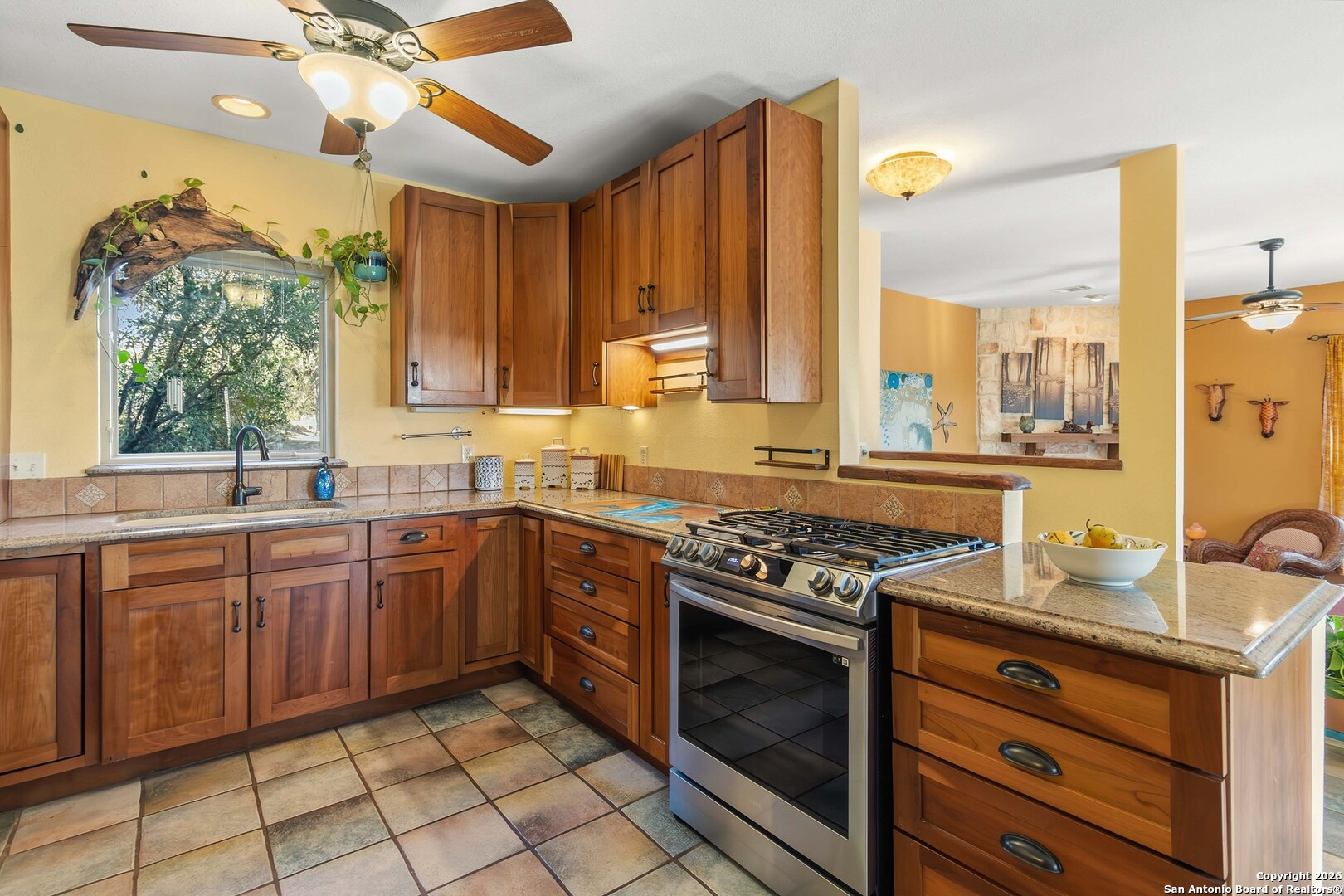 9623 Requa Road Helotes, TX 78023 - Photo 15 of 49 a kitchen with a stove a sink and a window